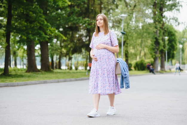 A garota grávida em passeio no parque da cidade