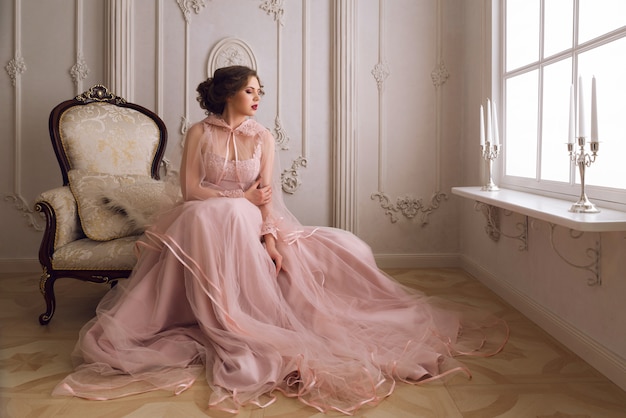 Foto a garota linda em um lindo vestido rosa e capa rosa no palácio