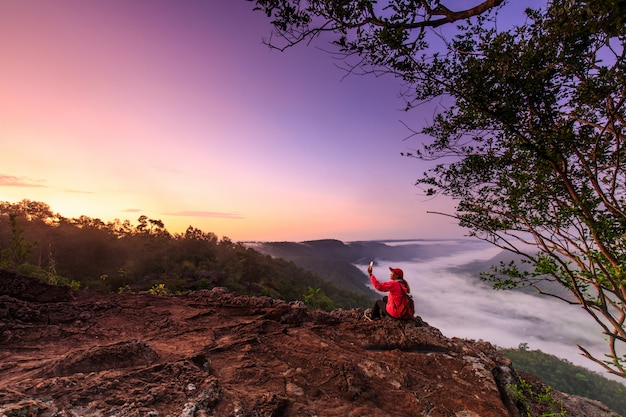 Foto a garota na jaqueta vermelha em pé na montanha