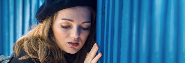 A garota na parede azul de boina e saia Mulher francesa elegante na sombra da cidade