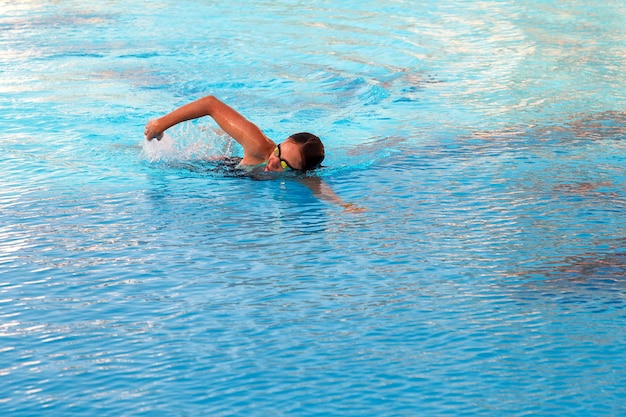 A garota nada na piscina em estilo crawl