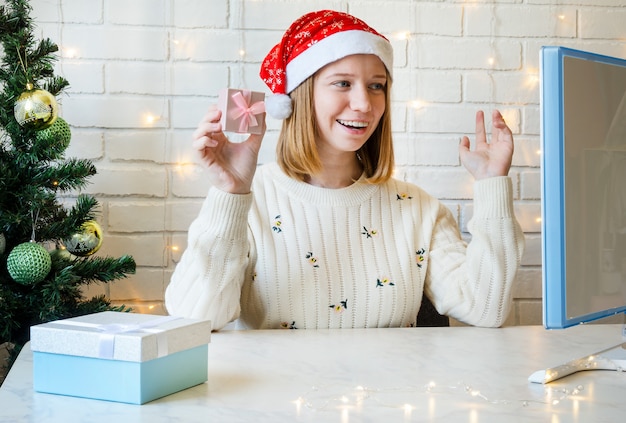 A garota no computador se comunica online e deseja feliz natal