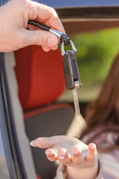 A garota pega a chave do carro Venda e aluguel de carros Concessionária de automóveis