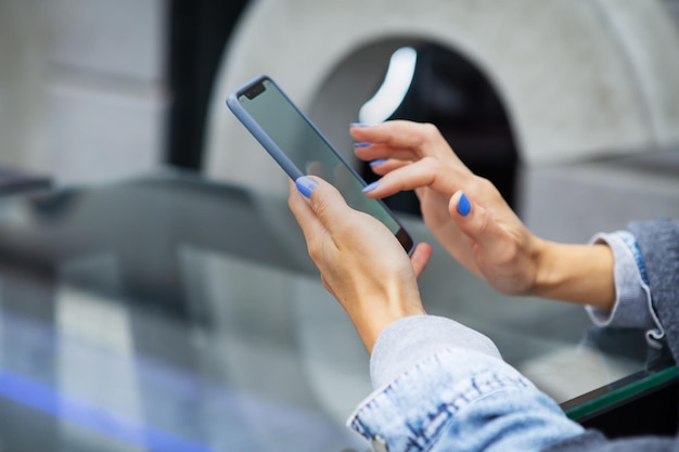 A garota se senta em um café e segura um telefone de toque, um robô e comunicação via Internet Serhu view