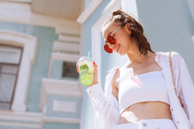 Foto a garota tem na mão um coquetel refrescante de verão na cidade