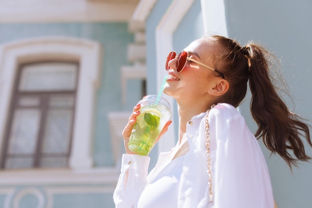 A garota tem na mão um coquetel refrescante de verão na cidade