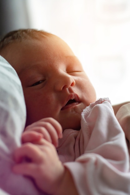 Foto a garotinha fofa dorme nas mãos da mãe