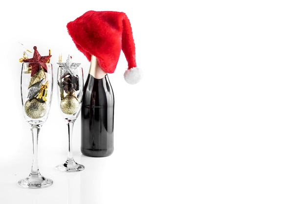 A garrafa de champanhe com chapéu de Papai Noel e taça de champanhe com enfeites de Natal