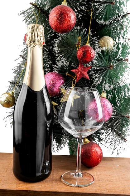 A garrafa de champanhe e o copo de vinho com a árvore de Natal