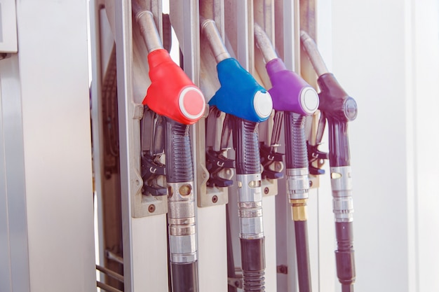 A gasolina e o diesel seguram o distribuidor no posto de gasolina.
