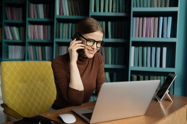 A gerente é uma mulher de óculos falando ao telefone com um cliente