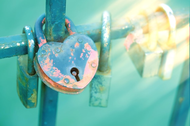 A grade da ponte com fechaduras de amor castelo em forma de coração em primeiro plano castelos coloridos com uma inscrição o juramento dos noivos em lealdade e amor vinculação dos laços conjugais