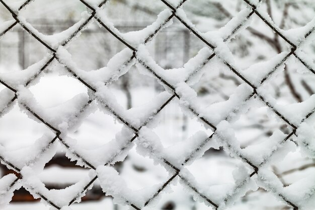 A grade de lajes de metal está coberta de neve.