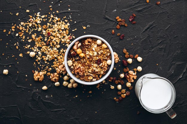 A granola de aveia deliciosa e crocante com frutos secos e grãos de nozes de mel é derramada