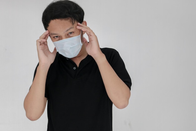 A gripe e a dor de cabeça do homem asiático doente estão sentadas com o uso de máscara Conceito de dor de gripe de doença Conceitos de saúde e corona