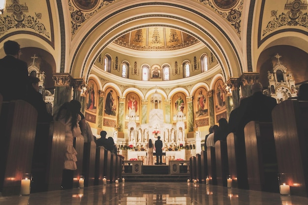A igreja de st. Francisco de Assis é decorado com velas e um casal em frente ao altar.