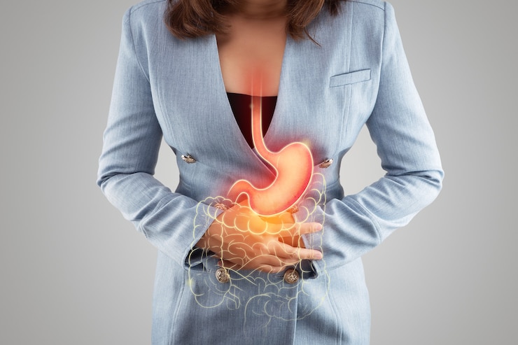 A ilustração do estômago e do intestino grosso está no corpo da mulher contra um fundo cinza