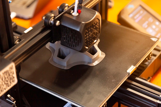 A impressora 3D imprime uma peça de protótipo. Foco seletivo.