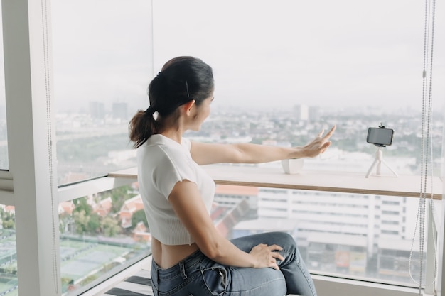 A influenciadora feminina está gravando um clipe dela mesma com o smartphone