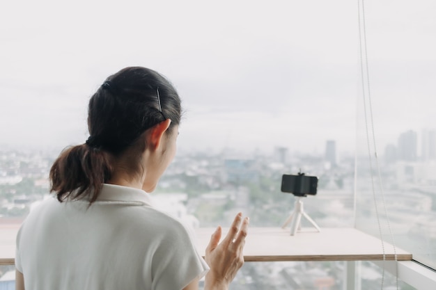 A influenciadora feminina está gravando um clipe dela mesma com o smartphone