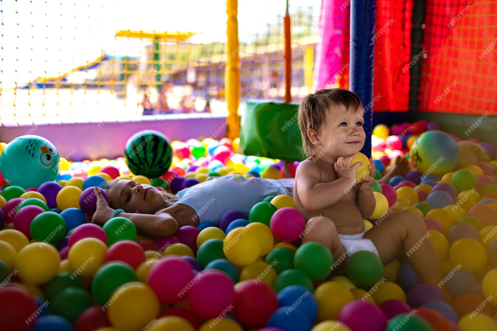 irmão com irmã jogando na piscina de bolinhas coloridas