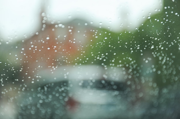 A janela do carro coberta de gotas de chuva simboliza a beleza e a tranquilidade da natureza.