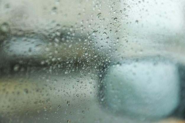 A janela do carro coberta de gotas de chuva simboliza a beleza e a tranquilidade da natureza.