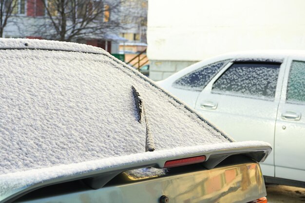 A janela traseira do carro está coberta de neve. Neve congelada em vidro