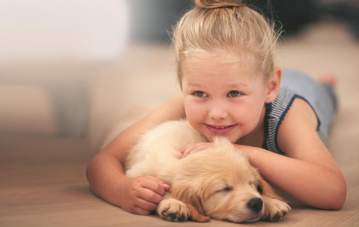 Foto a jovem abraça seu cachorrinho relaxa em casa e fica feliz com o cachorro golden retriever dormindo e a criança com um sorriso felicidade cuidando do animal de estimação e amando a criança com seu animal doméstico deitado no chão de madeira