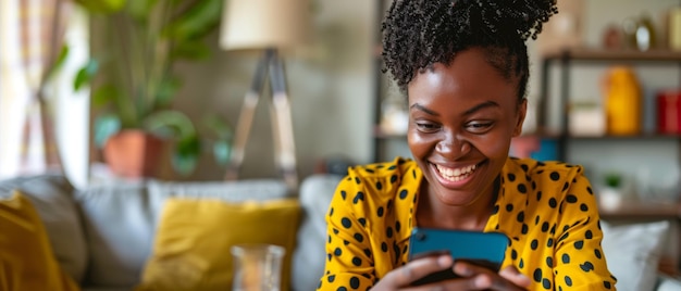 A jovem atrás da mesa está sorrindo e segurando um smartphone tecnologia moderna sendo usada por ela A mulher está olhando para o telefone enquanto ela está trabalhando ou aprendendo remotamente e está enviando mensagens de texto