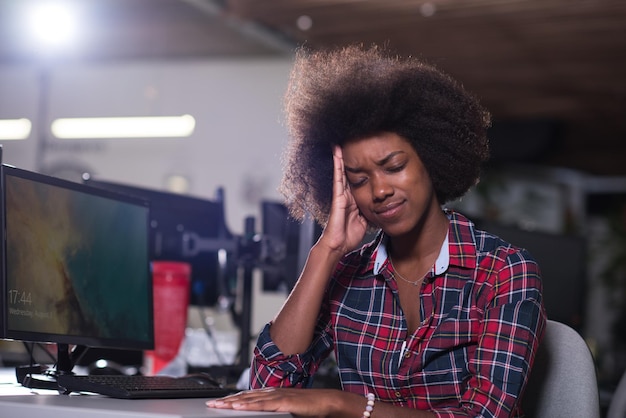 A jovem e bela mulher afro-americana bem-sucedida se sente cansada em um grande escritório moderno