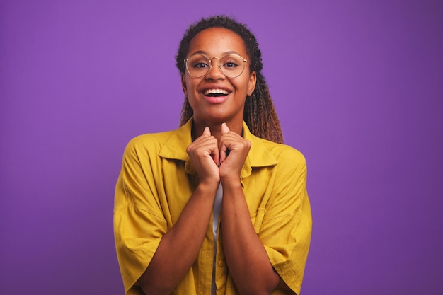 A jovem e bela mulher afro-americana sorri animadamente e olha para a câmera