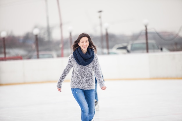 A jovem está patinando na pista, o inverno relaxa