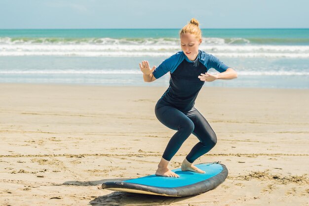 A jovem está treinando para ficar no surf antes da primeira aula de surf