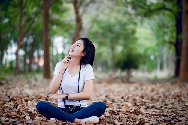 A jovem fotógrafa está feliz com a fotografia E sua pequena câmera No canto natural