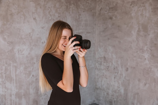 A jovem fotógrafa está tirando uma foto no estúdio doméstico aprender