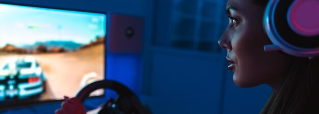 Foto a jovem gamer com fones de ouvido joga videogame no quarto escuro