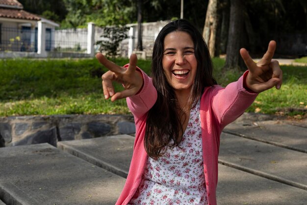 A jovem latino-americana 33 está feliz e sorrindo para a chegada da primavera, ela está sentada no parque recebendo o calor do sol Conceito de primavera