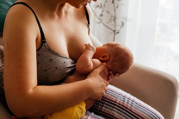 Foto a jovem mãe quer amamentar seu bebê recém-nascido