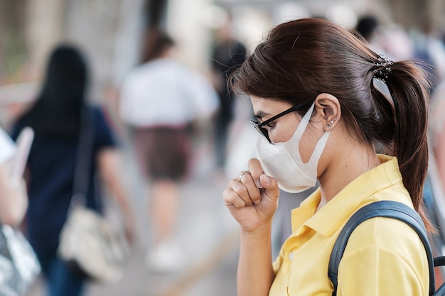 A jovem mulher asiática que usa máscara de proteção contra o novo coronavírus (2019-nCoV) ou o coronavírus Wuhan na estação de trem pública é um vírus contagioso que causa infecção respiratória.