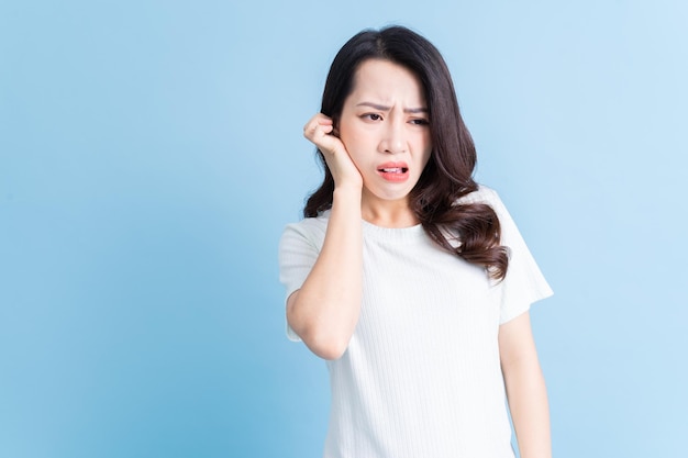 A jovem mulher asiática sente toothachexa