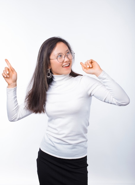 A jovem mulher de sorriso está dançando sobre o branco.