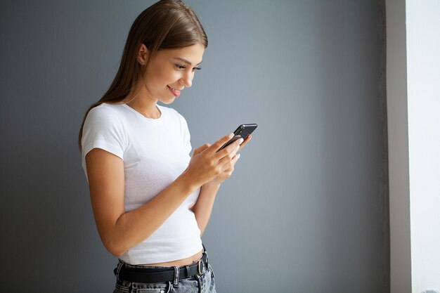 Foto a jovem mulher é viciada no telefone