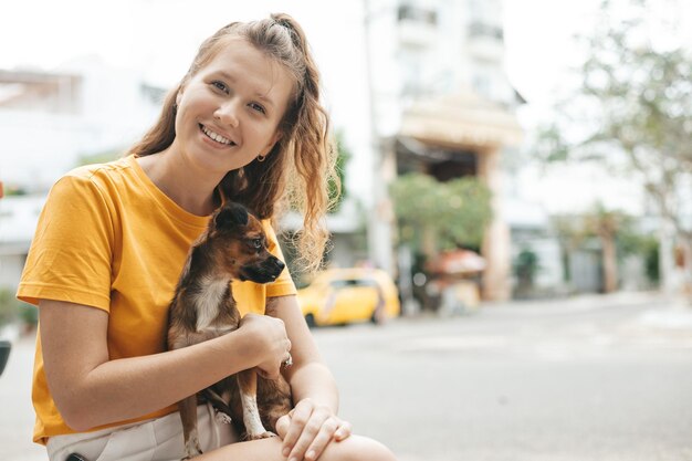 A jovem pegou um cachorro sem-teto na rua a mão de uma pessoa acaricia o cachorro abandonado um cachorro sem-teto assustado em um abrigo para cães