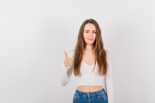 A jovem sorridente está mostrando o gesto perfeito no fundo branco