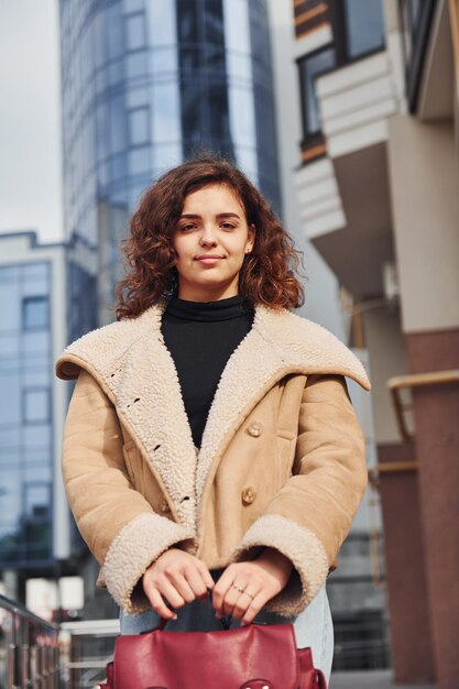 A jovem tem um passeio ao ar livre na cidade perto do edifício comercial