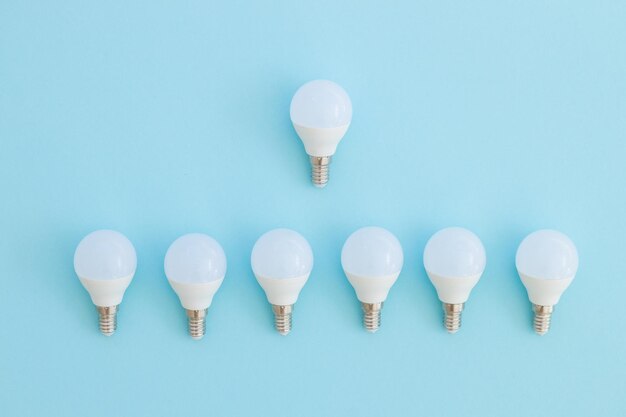 A lâmpada LED está sobre um fundo azul pastel Conceito de economia de energia Minimalismo vista superior