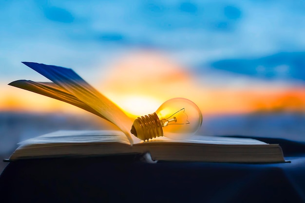A lâmpada repousa sobre um livro aberto conhecimento é lightxA