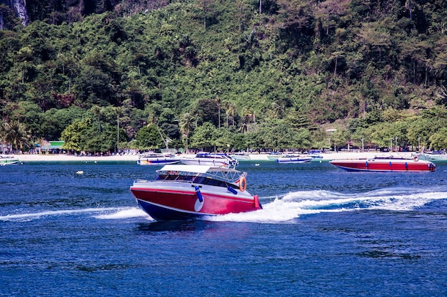 A lancha acelera Flutua para longe da costa, deixando para trás grandes ondas