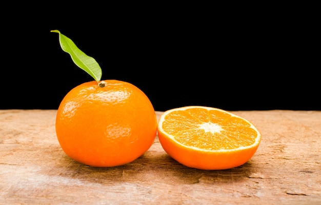 Foto a laranja cortada ao meio em uma mesa de madeira